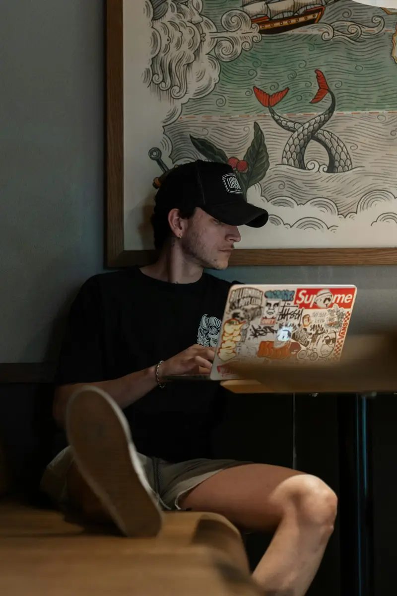 Miembro del corillo trabajando con la laptop sobre las piernas.